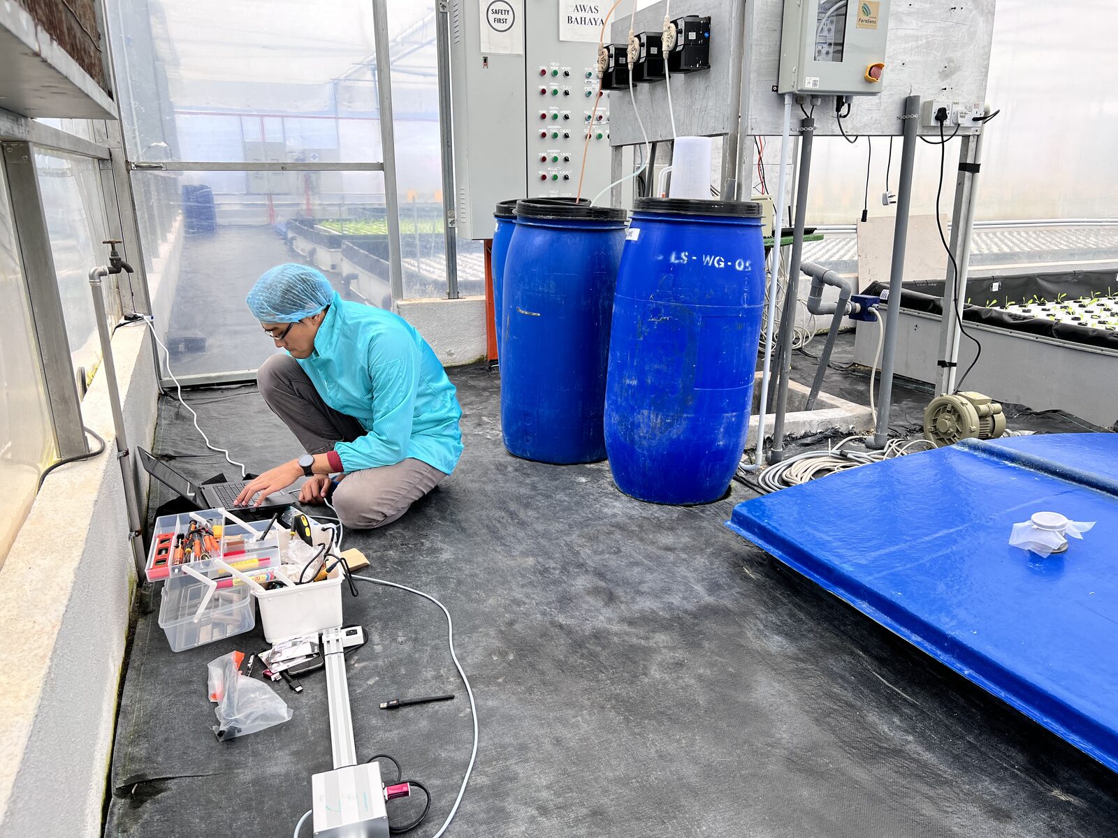 Technician installing trough-level sensors and AI camera instrumentation